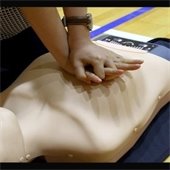 Person doing compressions using CPR dummy