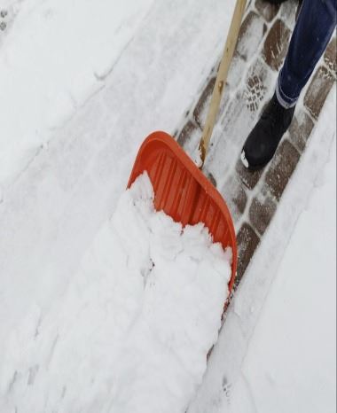 Person shoveling snow on walkway