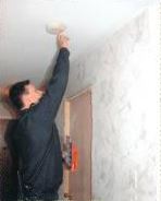 A fireman testing a fire alarm.